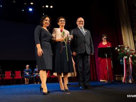 Na scenie w teatrze, od lewej Burmistrz Strumienia Anna Grygierek, uhonorowana laurem Srebrnej Cieszynianki Grażyna Gądek, Przewodniczący Rady Miejskiej Czesław Greń
